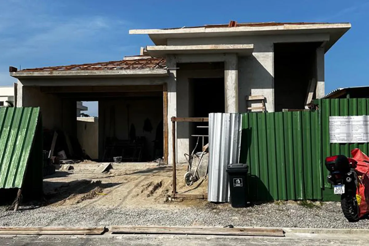 Casa em obra antes do projeto, com estrutura aparente e tapume