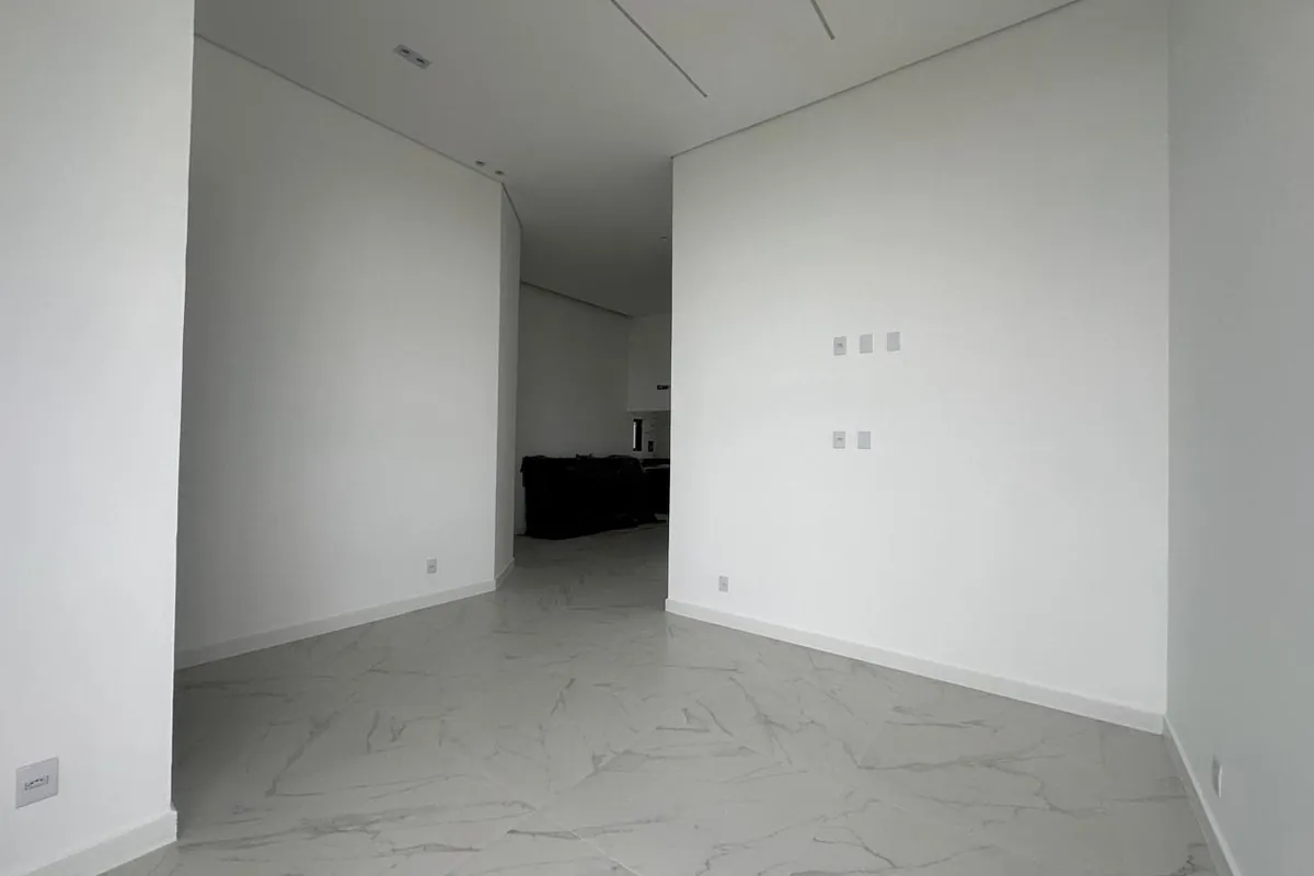 Sala vazia antes do projeto, com paredes brancas e piso porcelanato